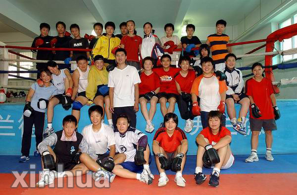 沈阳体育学院竞技体校女子拳击队的20几个队员与教练(中)在拳击台前一
